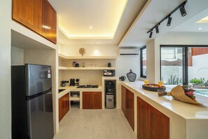 Eine moderne Küche mit einem Einbaukühlschrank, einem Gasherd und einer Kaffeemaschine.