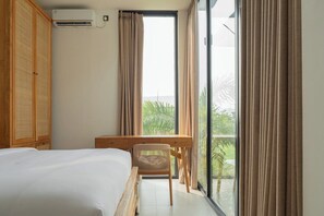 Ein Hotelzimmer mit einem Bett, einem Schreibtisch und Blick auf Grünfläche.