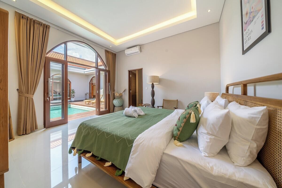 Une chambre d’hôtel avec un lit, une vue sur une piscine et une porte donnant sur un espace extérieur.