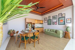 A modern living room with a dining area, wooden ceiling, and artwork on the walls. - Brand NEW Paradise Villa, Huge Pool, Best Location (Kabupaten Badung)