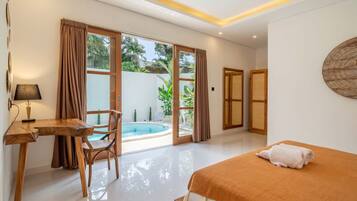 Ein Hotelzimmer mit Bett, Schreibtisch, Stuhl, einem kleinen Pool und großen Fenstern.