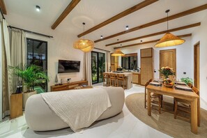 A modern living room with a sofa, dining table, and kitchen area. - Serene 2BR Escape in Prime Ubud - Pool+Lush Jungle (Kabupaten Gianyar)