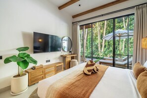 A hotel room with a large bed, a television, a wooden dresser, a potted plant, and a view of the outdoors. - Serene 2BR Stay in Top Ubud's Spot w Pool & Garden (Kabupaten Gianyar)