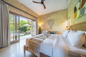 A spacious bedroom with a large bed, a ceiling fan, and a view of a lush garden through a sliding glass door. - Serene Ubud 2BR Stay • Garden Bath • Private Pool (Ubud)