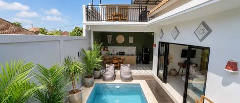 Une maison moderne avec une piscine, un balcon et une cuisine.