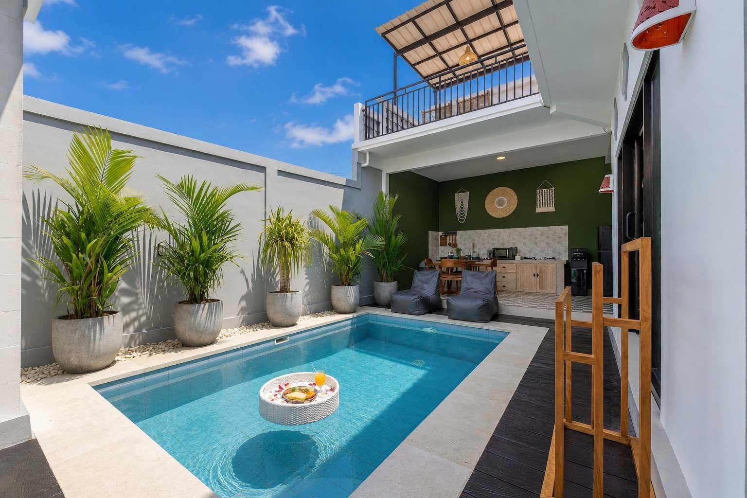 Un área de piscina moderna al aire libre con zona de comedor y balcón.