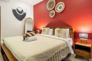 Ein Schlafzimmer mit einem Bett, einem Nachttisch, einer Lampe und Wanddekoration.