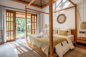 A four-poster bed with a view of a garden through an open door. - Chic 1BR Stay w Garden Tub&Pool by Tropical Jungle (Kabupaten Gianyar)