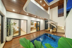 A modern interior with a swimming pool, wooden flooring, and a staircase leading to an upper level. - Designer 5BR in 500 m to Sanur Beach w Pool+Patio (Kota Denpasar)