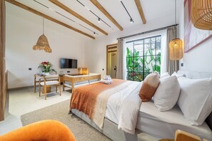 Een slaapkamer met een bed, een bureau en een televisie.