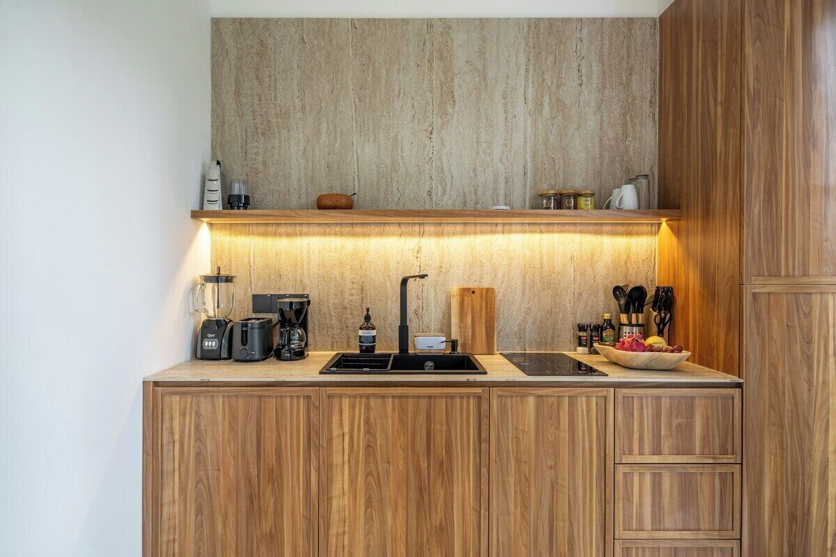 A compact kitchen with wooden cabinets, a built-in sink, and a countertop with various appliances.