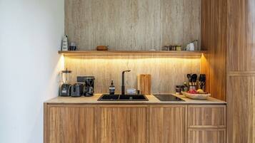 A compact kitchen with wooden cabinets, a built-in sink, and a countertop with various appliances.