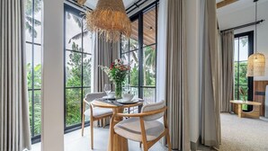 Un comedor moderno con una mesa redonda, dos sillas y una lámpara colgante.