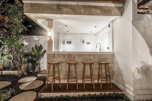A bar area with stools and a view of a bathroom. - Peaceful 3BR Villa in Lush Ubud, Large Pool&Garden (Kabupaten Gianyar)