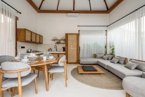 A modern living space with a dining area, sofa, and kitchen. - Peaceful 3BR Villa in Lush Ubud, Large Pool&Garden (Kabupaten Gianyar)