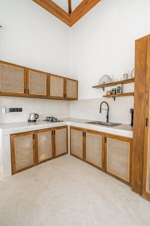 A kitchen with wooden cabinets, a white countertop, a sink, and a coffee machine. - Peaceful 3BR Villa in Lush Ubud, Large Pool&Garden (Kabupaten Gianyar)