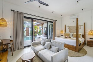 A modern bedroom with a large bed, a sofa, and a desk. - New Chic 2BR Villa • Huge Pool • Garden Bath+Patio (Gianyar Regency)
