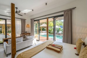Une chambre d’hôtel comprenant un lit, un coin salon, une piscine et une vue sur l’extérieur.