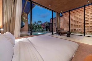 A modern bedroom with a large bed, a view of a swimming pool, and a wooden partition. - Tropical 1BR Hideaway in Ungasan w Pool & Patio (South Kuta)