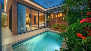 Ein moderner Poolbereich im Freien mit einem gläsernen Schlafzimmer und einer gemütlichen Sitzecke.