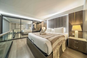 Ein modernes Hotelzimmer mit einem großen Bett, einem Nachttisch, einem Spiegel und Blick auf einen Balkon.