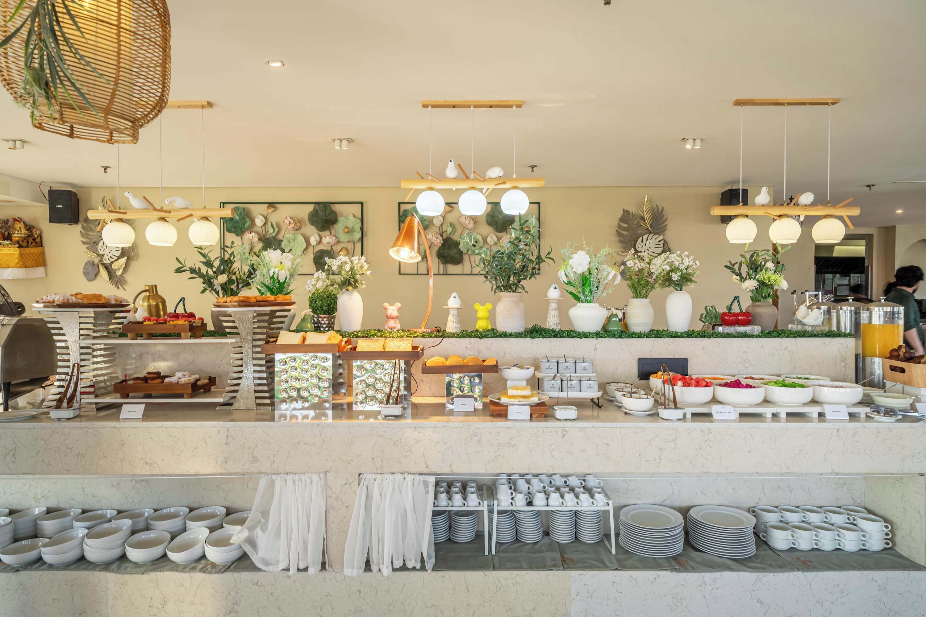 A buffet setup with various food items and a selection of bowls and cups.