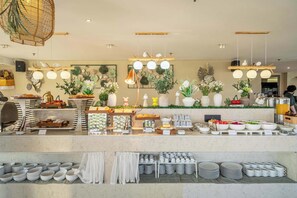 Un buffet proposant une variété de plats, ainsi qu’un assortiment de bols et de tasses.
