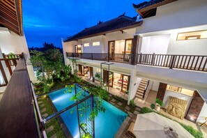 A multi-story building with a swimming pool, outdoor seating, and a Buddha statue. - PROMO NEW 1 BR in Serene Ubud • Pool, Garden&Patio (Gianyar Regency)