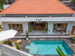 A modern house with a swimming pool, a dining area, and a covered patio. - Amazing Jungle view, 3BDR,  Canggu, huge Pool (Kabupaten Badung)