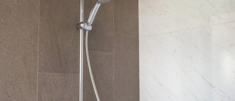 A shower with a handheld showerhead and a wall-mounted rain showerhead.