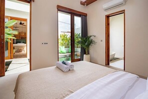 A hotel room with a bed, a potted plant, and a view of a balcony. - Private Villa in Seminyak | Big Pool | ALL NEW (Kota Denpasar)