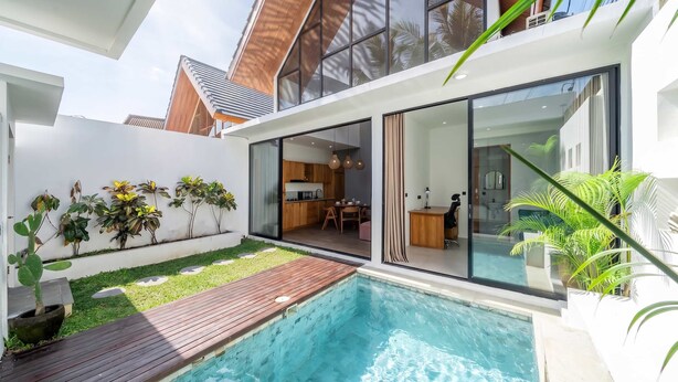 Une maison moderne dotée d’une piscine, d’une cuisine et d’un coin repas.