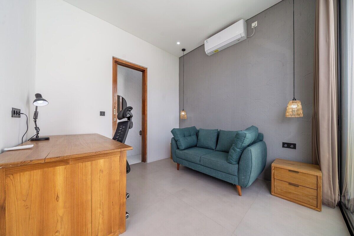 Ein modernes Wohnzimmer mit einem Holztisch, einem blaugrünen Sofa und einem kleinen Nachttisch.