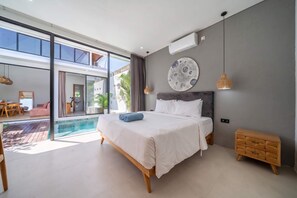 A modern bedroom with a large bed, a view of the pool, and a dining area. - Peaceful 1BR Retreat w Pool in Prime Seminyak (Kota Denpasar)