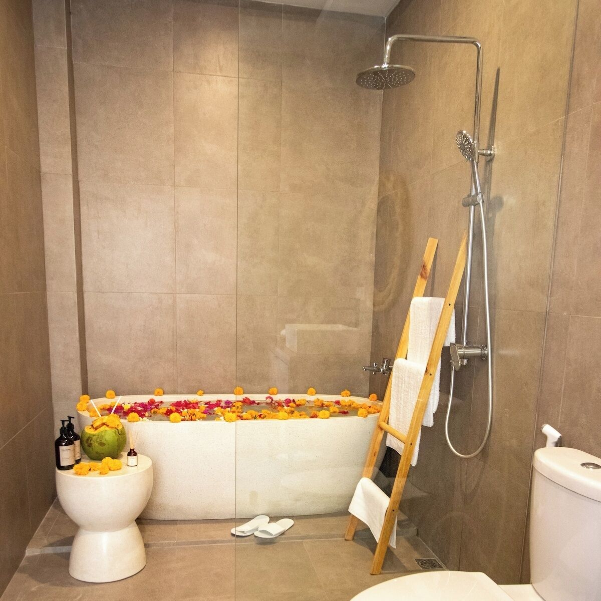 Ein Badezimmer mit Badewanne, Dusche, Toilette und einem Holzstuhl.
