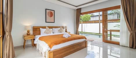 Un dormitorio moderno con una cama grande, cabecera de madera y vista a una piscina.