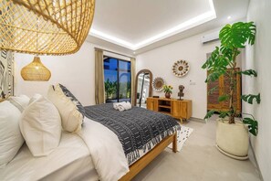 Une chambre à coucher moderne avec un lit, une table de chevet, un miroir et une grande plante en pot.
