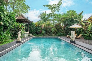 A rectangular pool with clear water, surrounded by lush greenery and a traditional gazebo. - New 3BR Villa in Serene Ubud Complex w Spa+2 Pools (Kabupaten Gianyar)