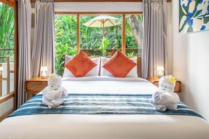 A hotel room with a bed, two nightstands, a window with curtains, and a view of greenery outside. - Tranquil 1BR Hideaway in Central Ubud w Pool+Patio (Kabupaten Gianyar)
