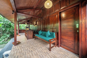 A wooden room with a sofa, a bench, and a door. - Cozy 1BR Stay w Pool, Garden & Patio, Central Ubud (Kabupaten Gianyar)