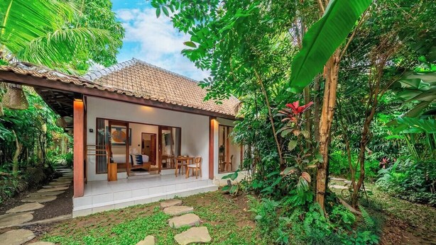A house with a tiled roof, a covered porch, and a stone pathway leading to the entrance. - -20% OFF NEW Cozy 1BR in Ubud w Pool, Garden&Patio (Ubud)
