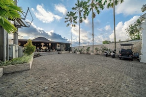 A paved courtyard with a building featuring a sloped roof and outdoor seating.