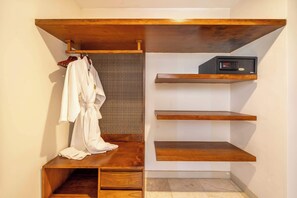 A bathroom with a wooden vanity, a towel rack with a white bathrobe, and a wall-mounted radio.