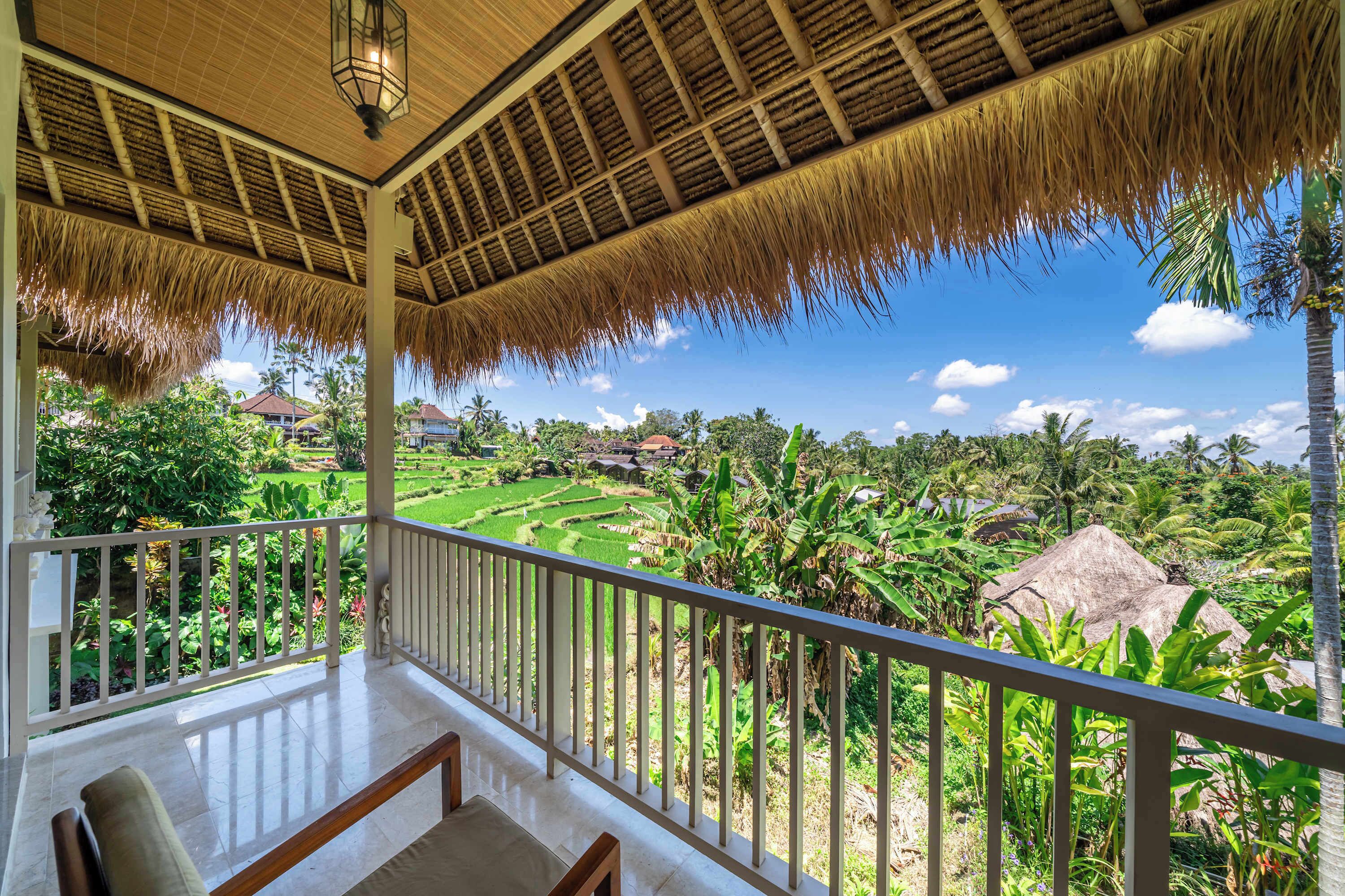 A balcony with a view of terraced fields and houses.