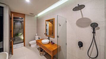 Ein modernes Badezimmer mit Duschkabine aus Glas, einem Holzbadezimmermöbel und einer weißen Toilette.