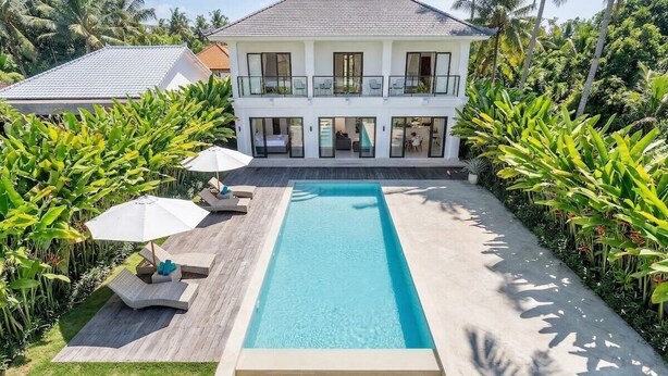 A two-story house with a swimming pool, surrounded by lush greenery and palm trees. - Serene 3BR Villa w Huge Pool+Garden • Central Ubud (Sukawati)