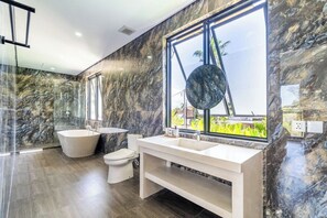 A modern bathroom with a freestanding bathtub, a large mirror, and a vanity with a sink. - Serene 3BR Villa w Huge Pool+Garden • Central Ubud (Sukawati)