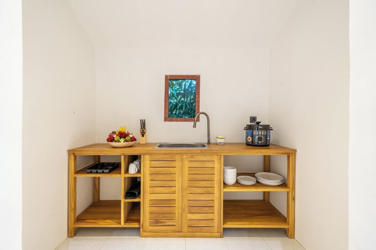 Een kleine keuken met een houten aanrecht, een spoelbak en een koffiezetapparaat.