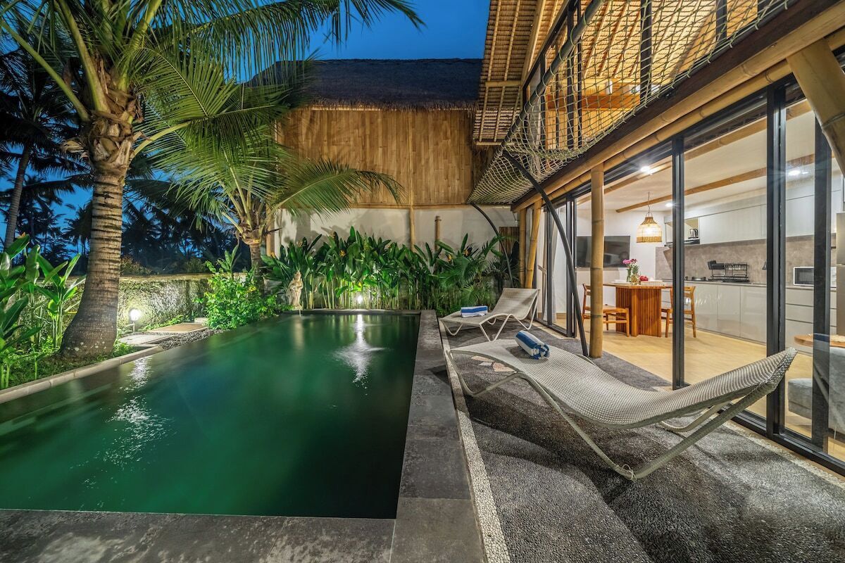 Ein Poolbereich mit Liegestuhl, einer Hängematte und Blick auf die Küche und den Essbereich.
