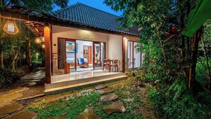 A modern house with a tiled roof, a covered porch, and a garden with a stone pathway. - Elegant New 2BR in a Complex w Spa, 2 Pools+Garden (Ubud)